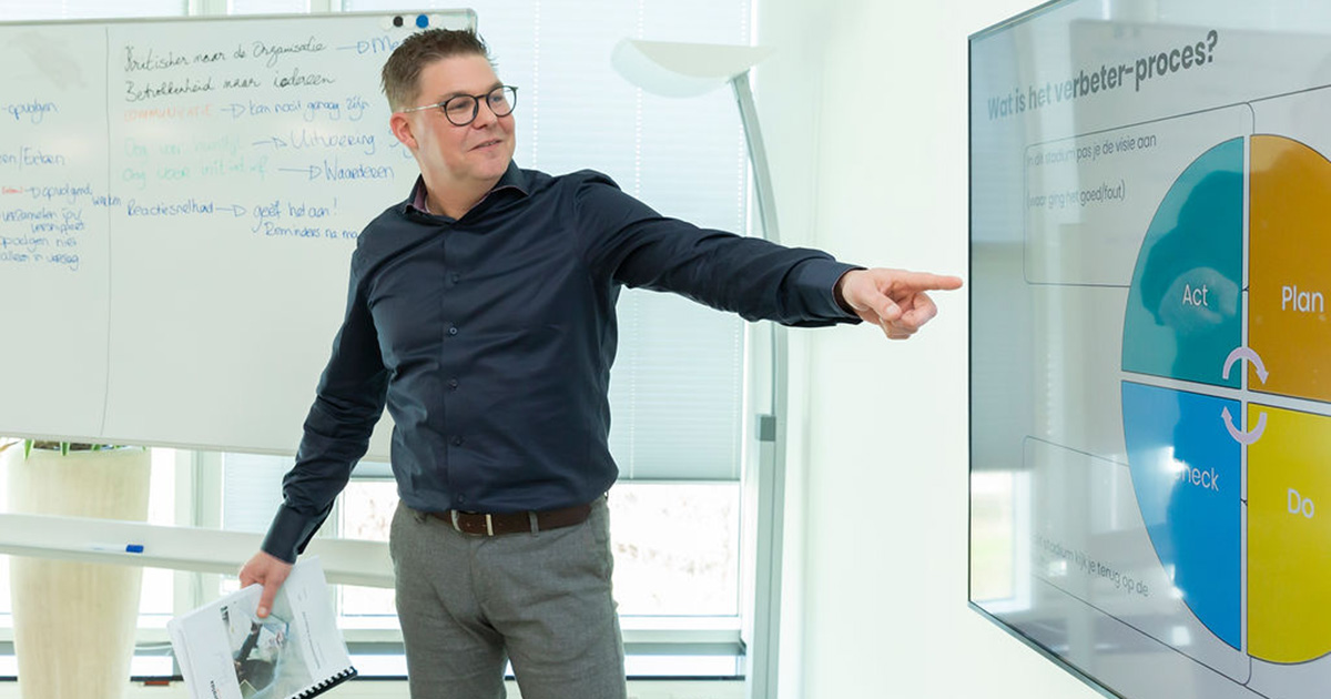 Presentator spreekt een zaal vol mensen aan